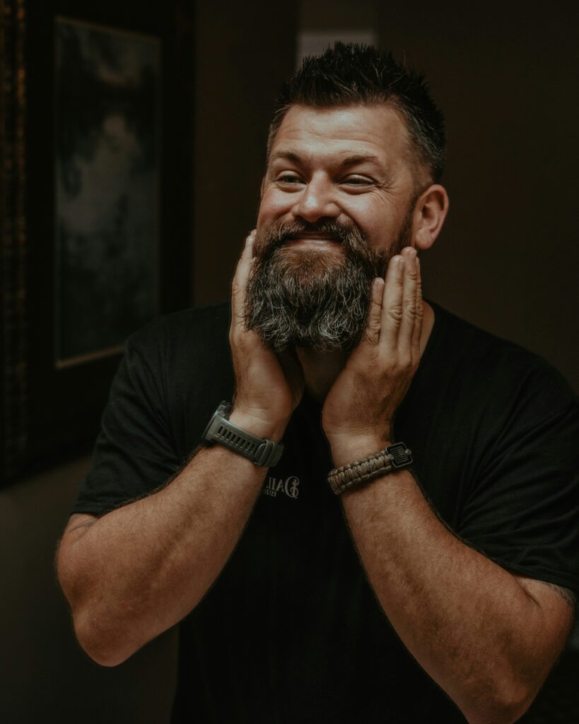 Man grooming his beard with beard oil.